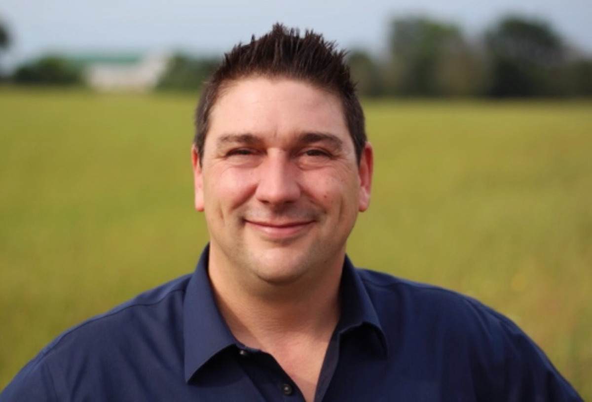 Sean Hunt standing in a green field in Middlesex Centre